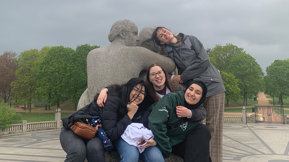 Students standing together in front of a statue