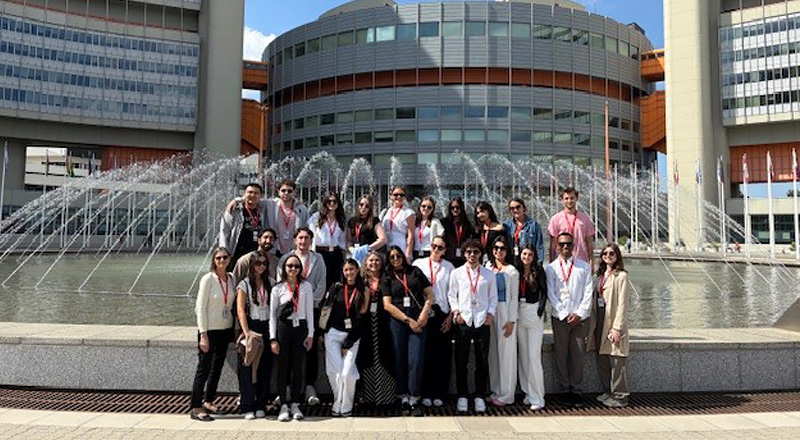 Students standing in front of a building and smiling