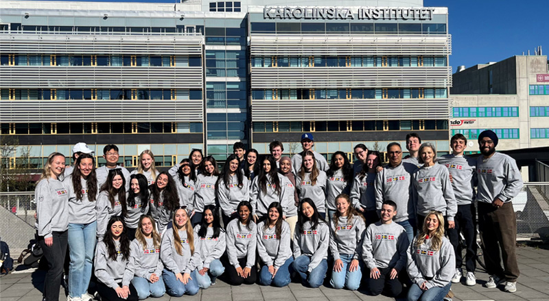 Students standing near Karolinska Instituet and smiling