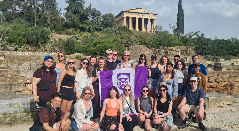 Students standing in Greece smiling